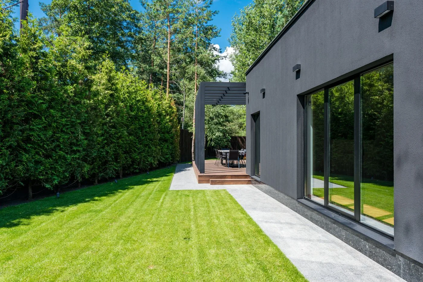 Manicured bright-green lawn beside a modern home on a sunny day